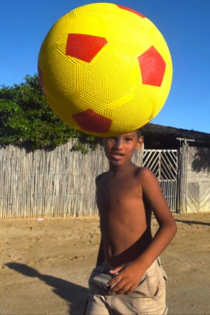 A boy from the Wayuu indigenous etnia plays soccer at a Christmas event where members of Kiwanis Foundation gave away gifts to Wayuu kids at the Manhaim Rancheria in Cabo de la Vela, Guajira department, Colombia, on December 23, 2017. Photo by Joaquin Sarmiento